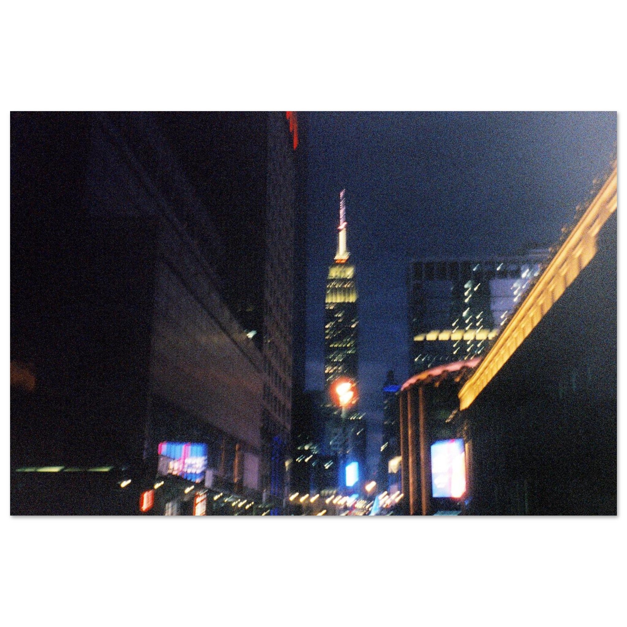 Nighttime 35mm film photograph of New York City 34th street lights with the Empire State Building in the distance.