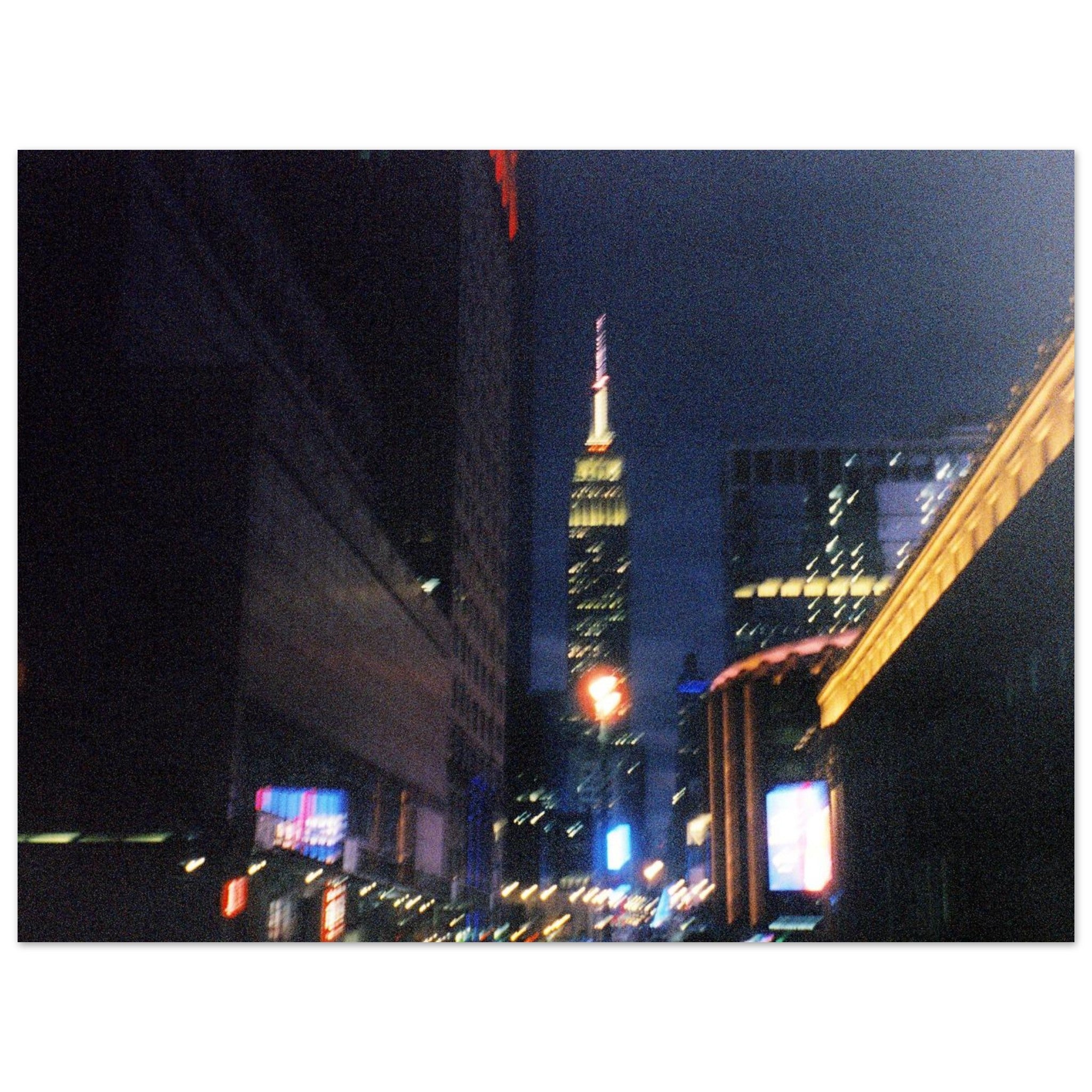 Nighttime 35mm film photograph of New York City 34th street lights with the Empire State Building in the distance.
