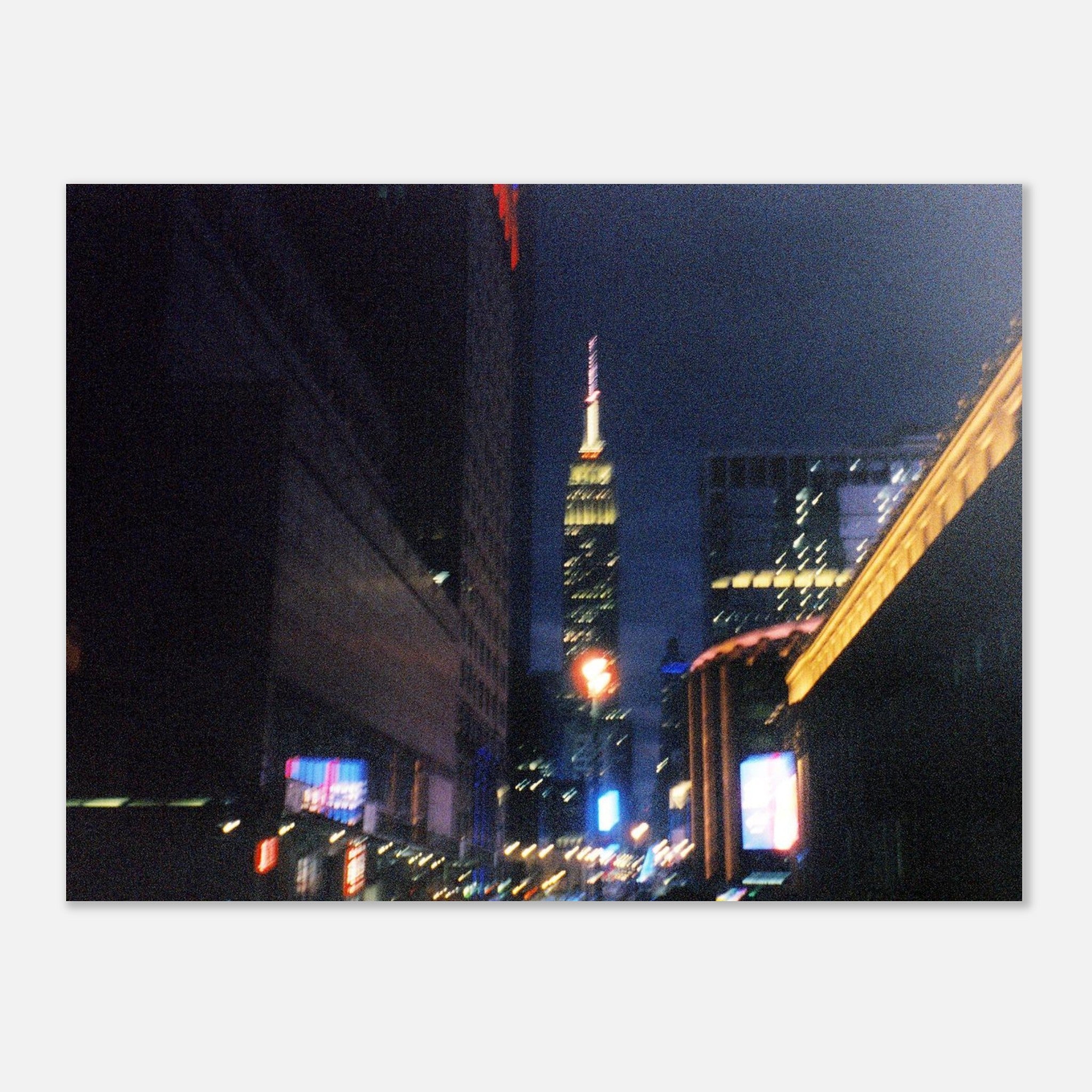 Nighttime 35mm film photograph of New York City 34th street lights with the Empire State Building in the distance.