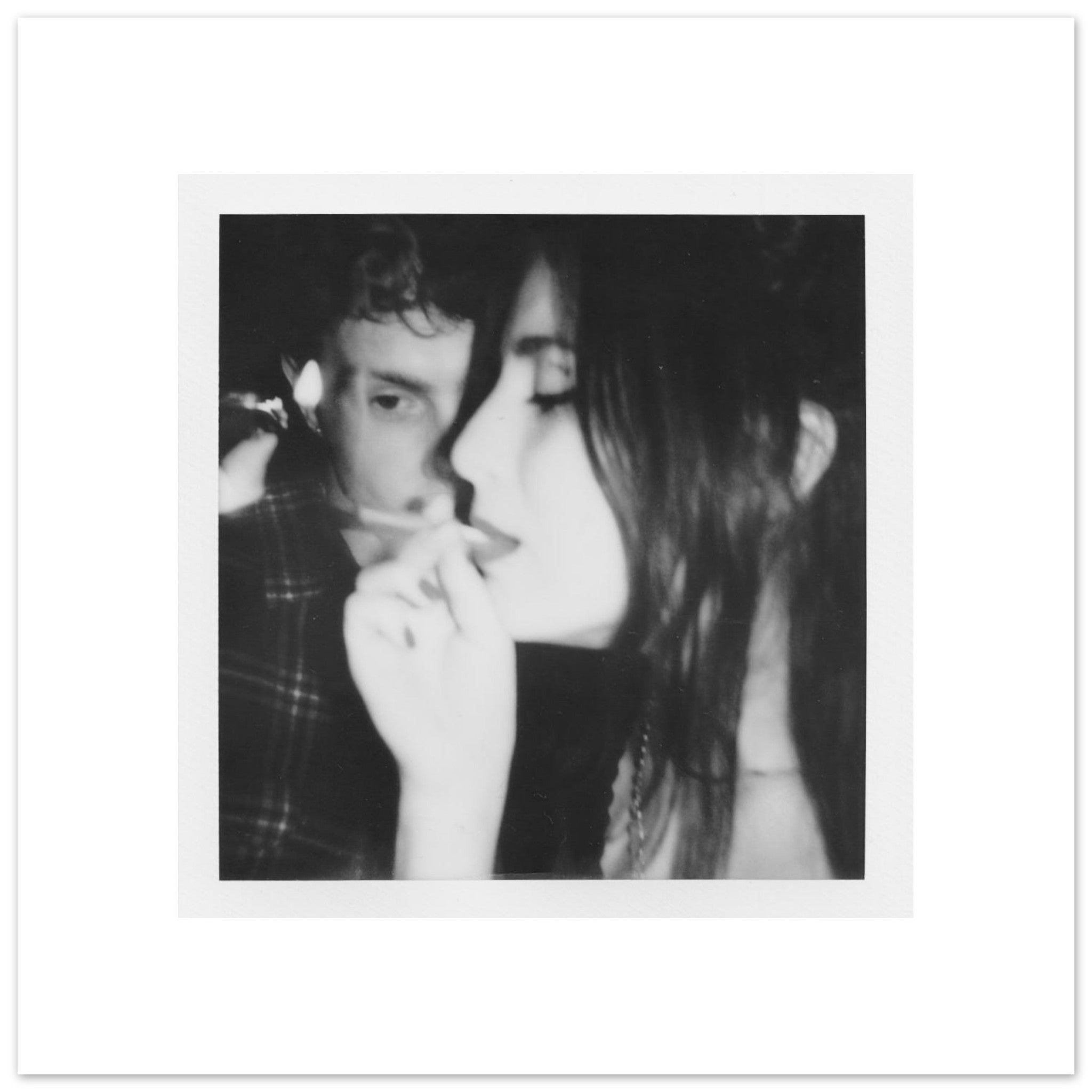 Black and white photo of two people close together, one with hand on chin.