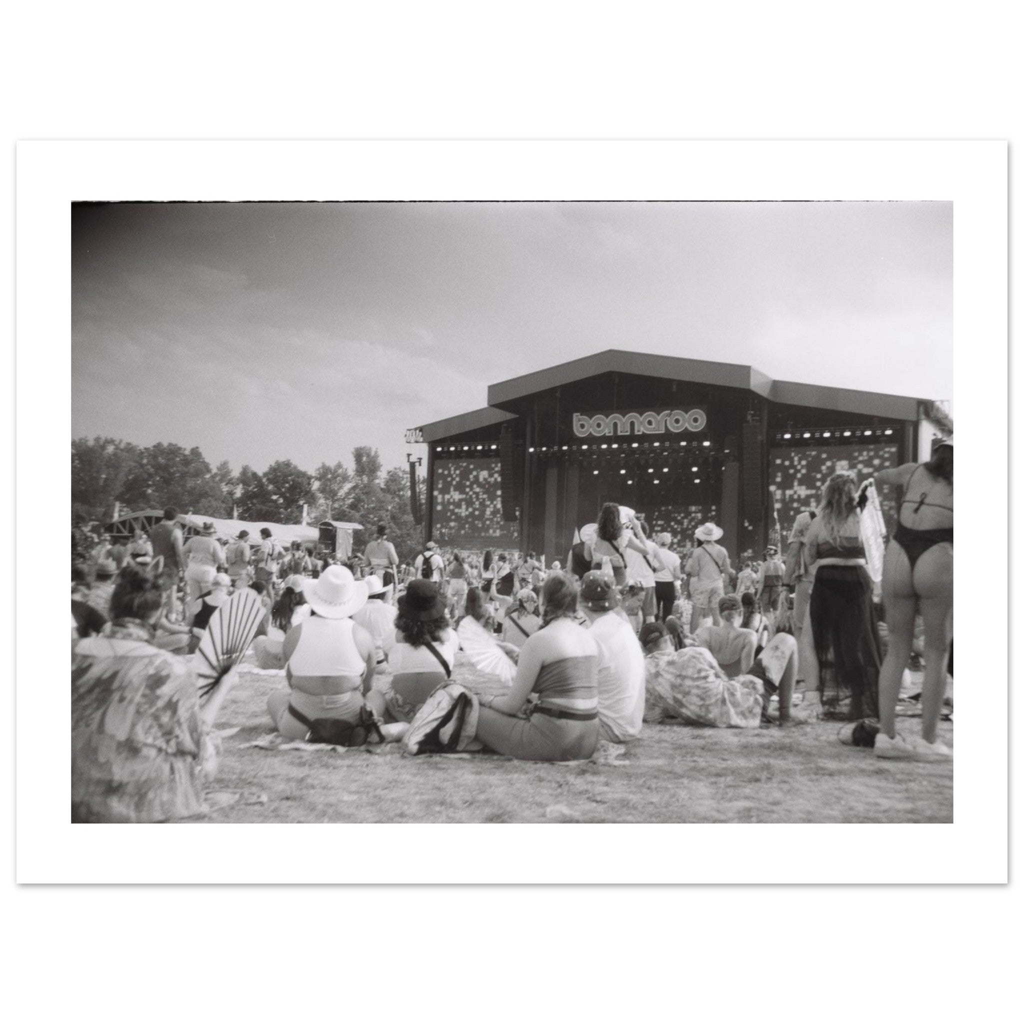 Black and white film photograph of a crowd at the Bonnaroo music festival facing the main stage.