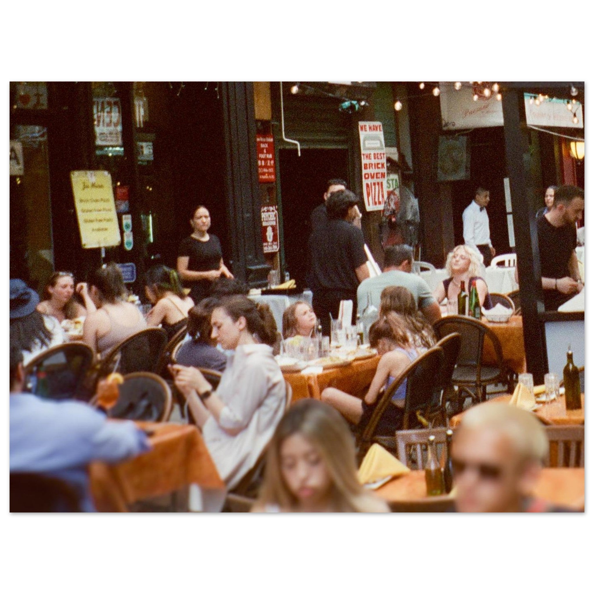 People dining at an outdoor restaurant with a lively atmosphere.