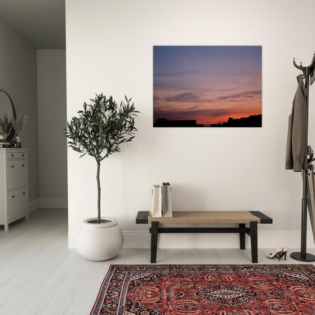 Modern interior with a plant, bench, and wall art of a sunset.