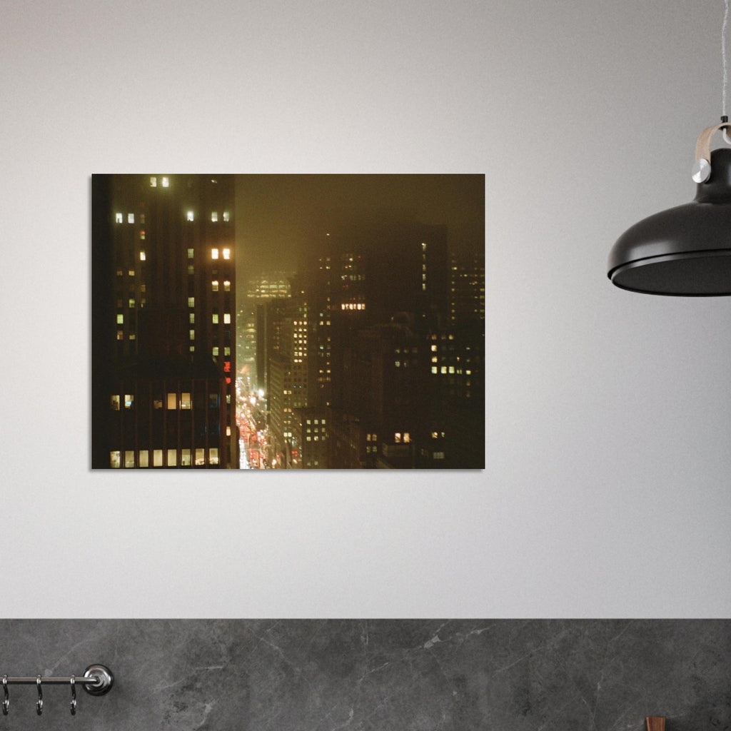 Film photo of wet city buildings at night across dark foggy streets