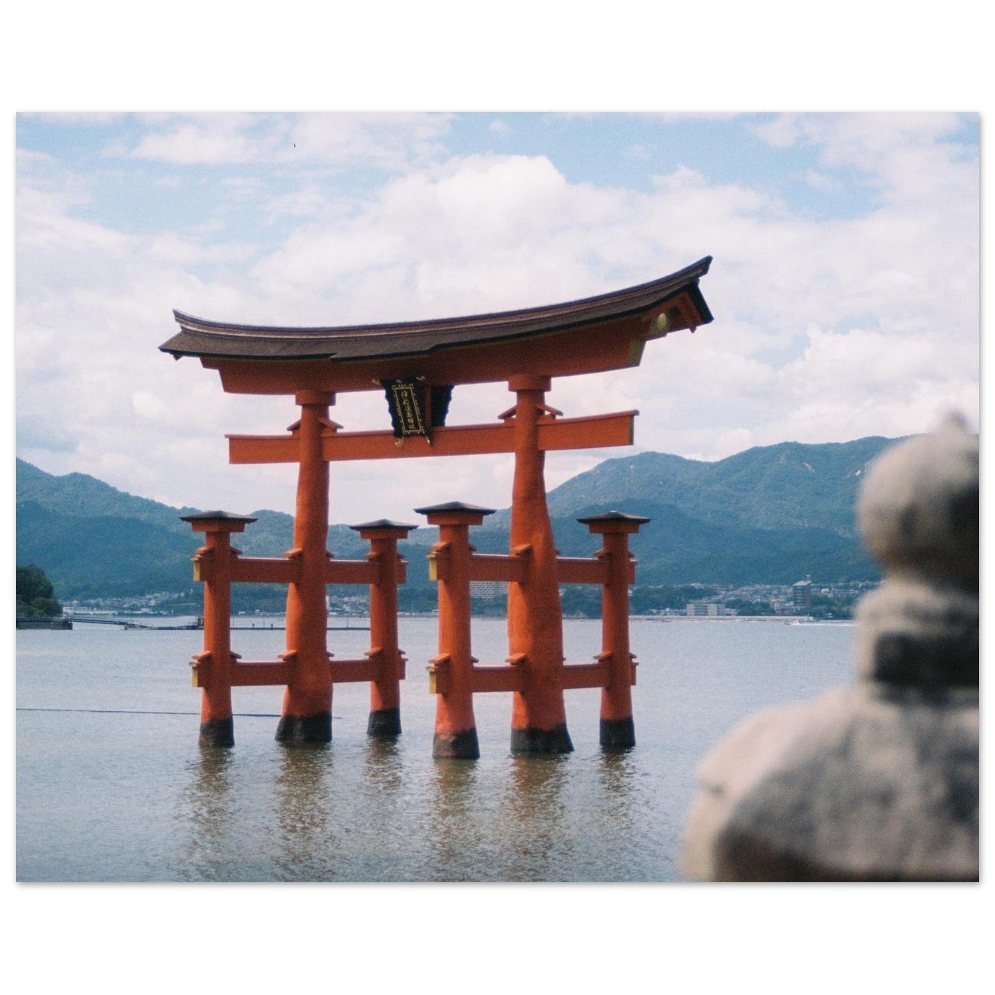 Film photograph of the iconic red torii gate of Itsukushima Shrine floating in the ocean