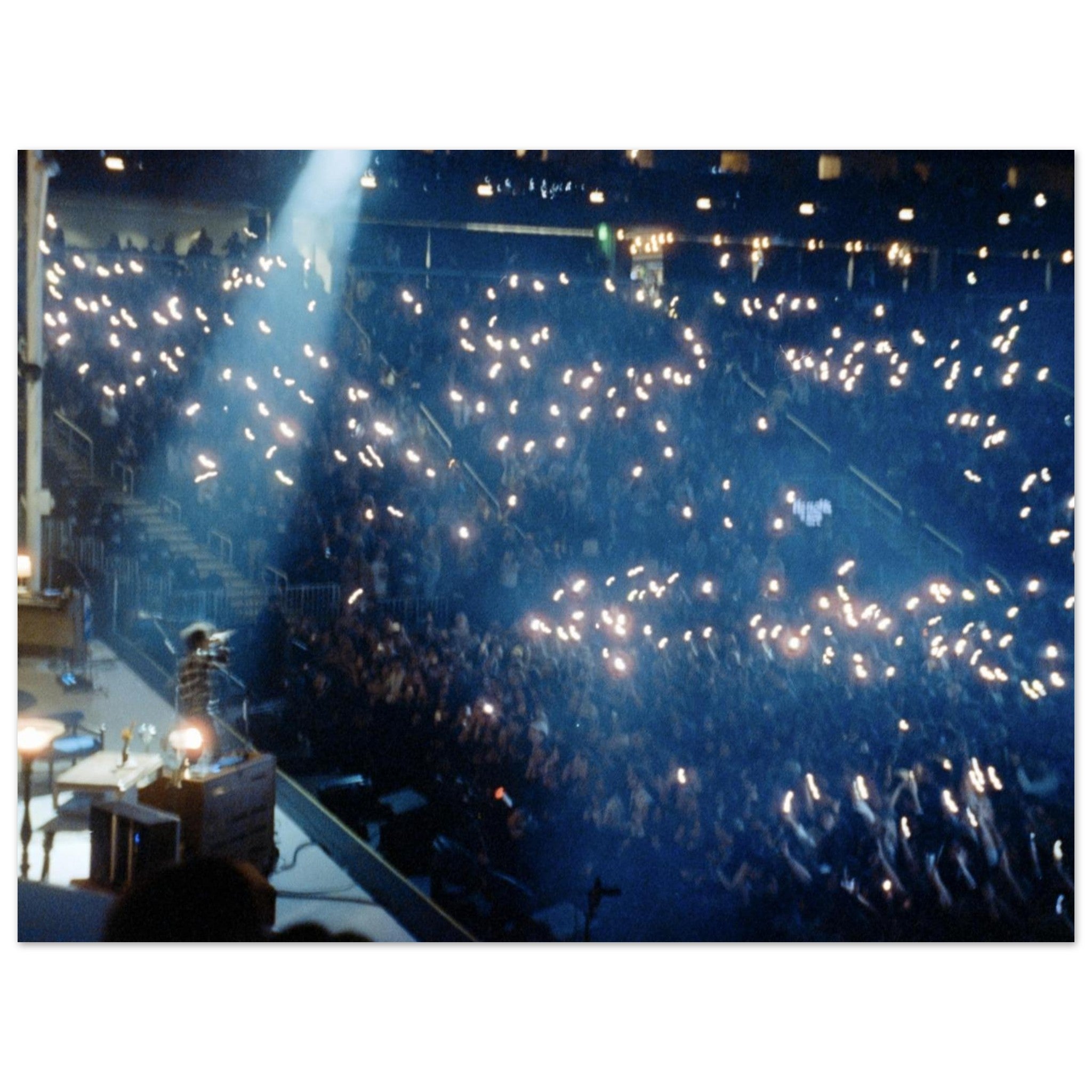 Film photograph of a concert crowd illuminated by bright blue arena lights and cell phone flashlights during the 197 concert