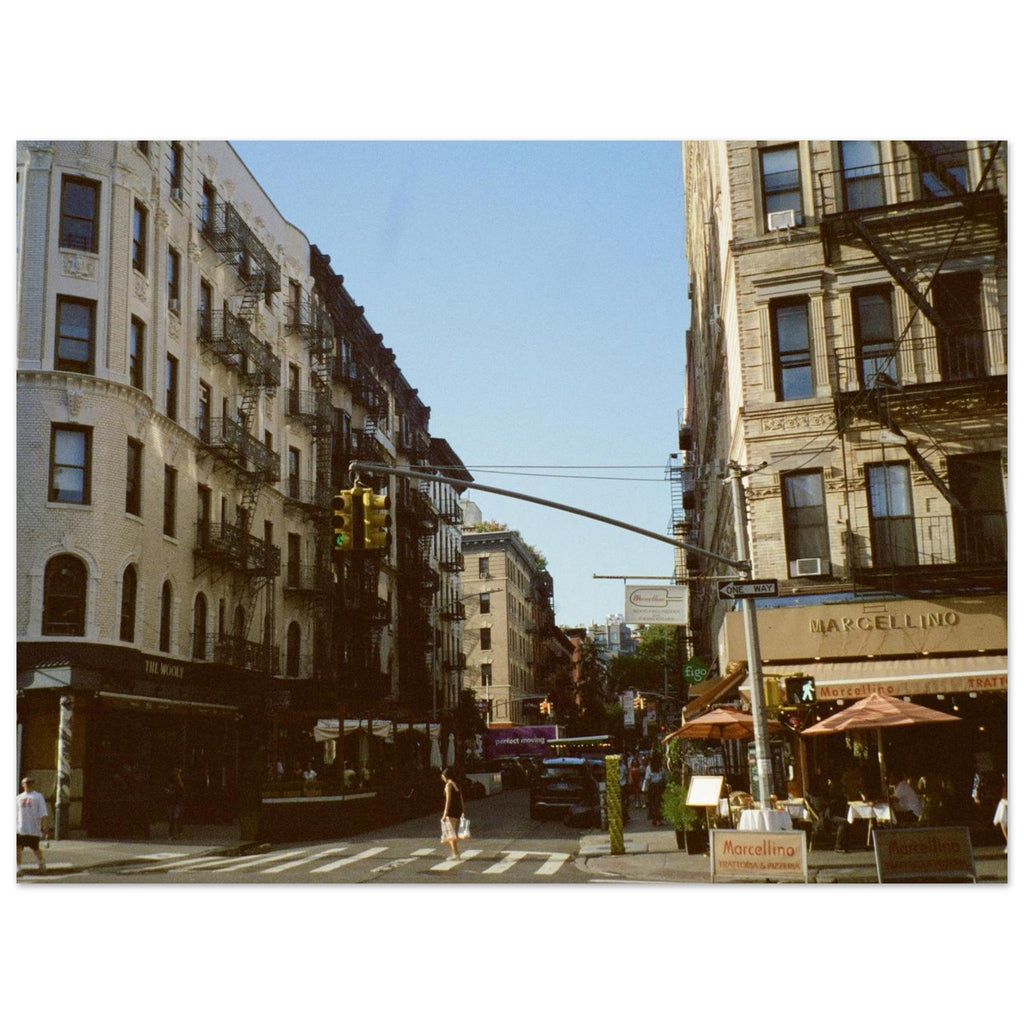 Street scene in an urban area with buildings, traffic lights, and pedestrians.
